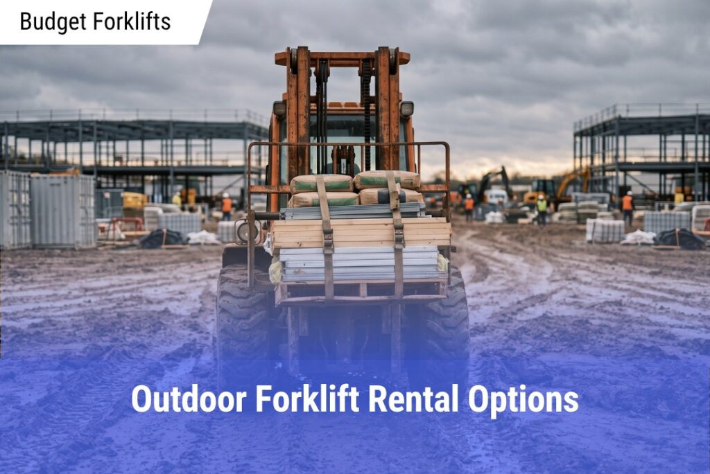 Rear view of an orange rough terrain forklift moving strapped wooden planks and bags of concrete across a rutted, muddy construction jobsite under a cloudy sky.