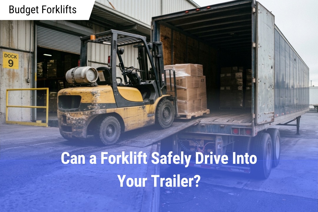 Yellow forklift driving up a metal ramp into a loaded dry van trailer at an industrial warehouse loading dock.
